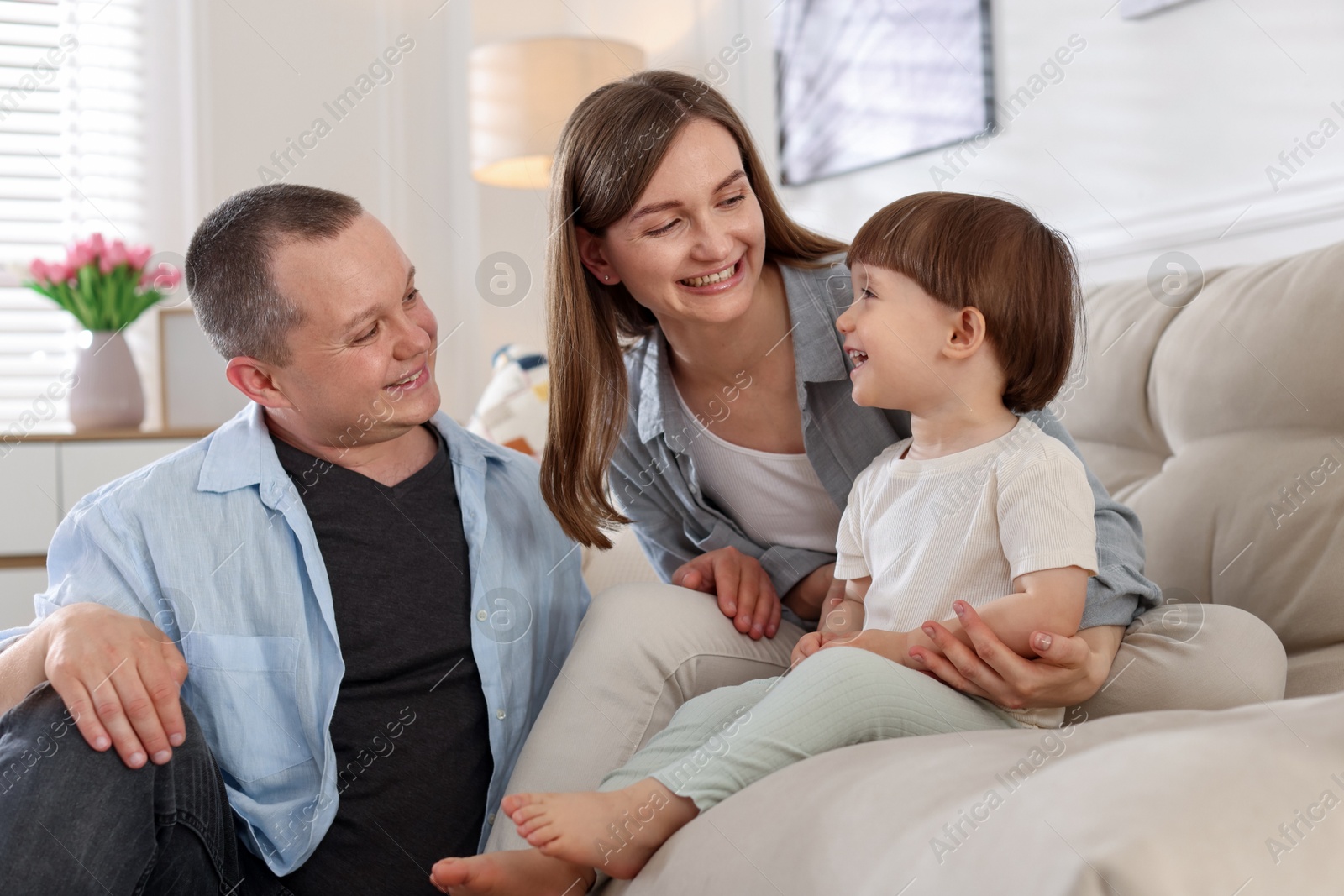 Cute little boy and his parents on sofa at home. Lovely family Photo of Cute little boy and his parents on sofa at home. Lovely family