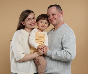 Photo of Happy parents and their baby boy on beige background. Lovely family