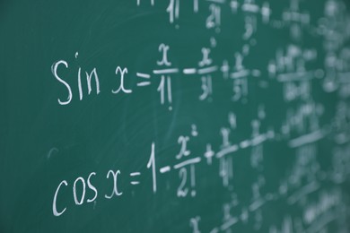 Photo of Different formulas written with chalk on blackboard, closeup