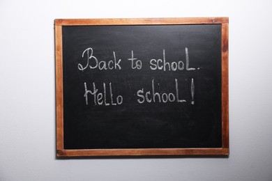 Photo of Phrases Back To School and Hello School with exclamation mark on blackboard