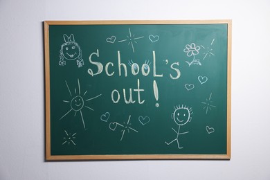 Photo of Phrase School's Out with exclamation mark and different drawings on blackboard