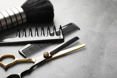 Photo of Different hairdresser's tools on grey table, closeup. Space for text