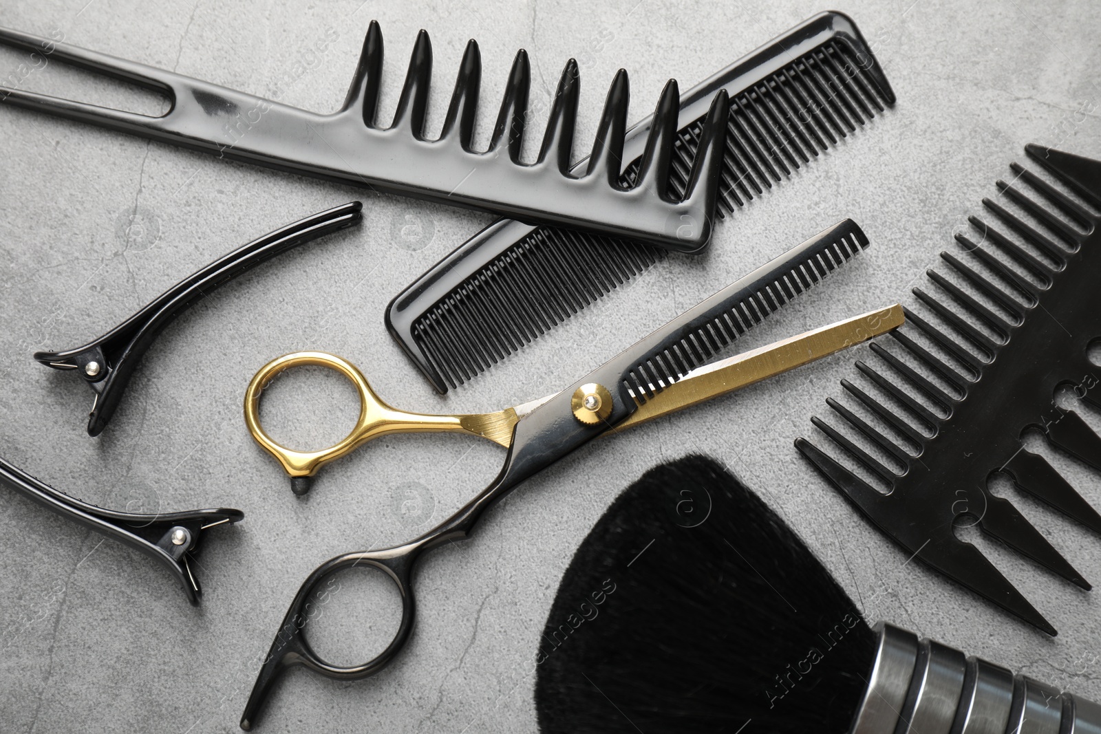 Different hairdresser's tools on grey table, flat lay Photo of Different hairdresser's tools on grey table, flat lay
