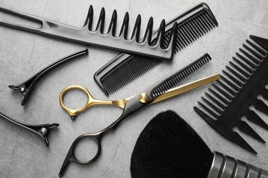 Photo of Different hairdresser's tools on grey table, flat lay