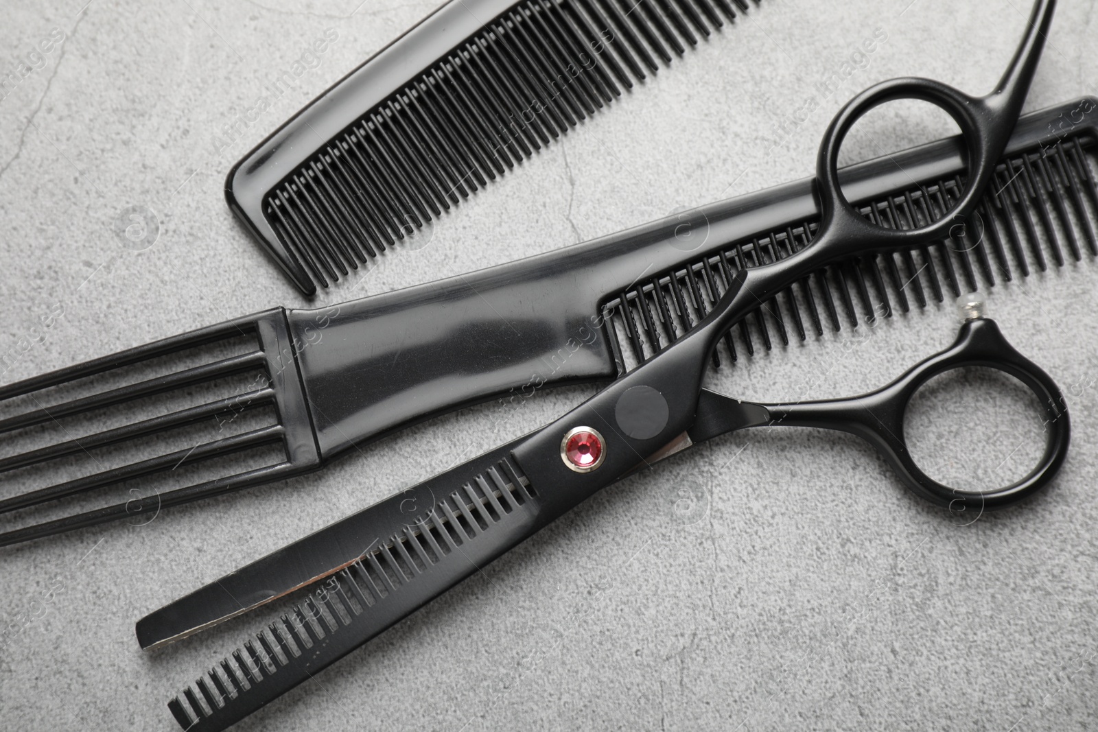 Different hairdresser's tools on grey table, flat lay Photo of Different hairdresser's tools on grey table, flat lay