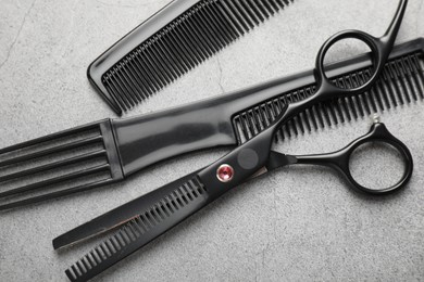 Photo of Different hairdresser's tools on grey table, flat lay