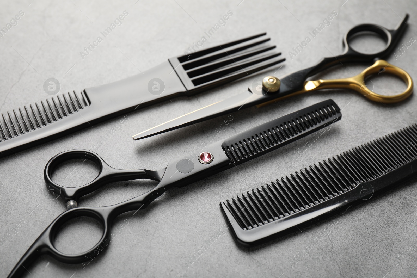 Different hairdresser's tools on grey table, closeup Photo of Different hairdresser's tools on grey table, closeup