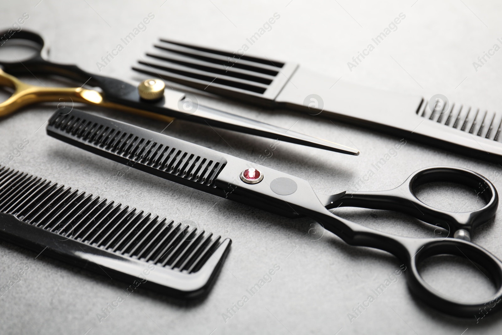 Different hairdresser's tools on grey table, closeup Photo of Different hairdresser's tools on grey table, closeup