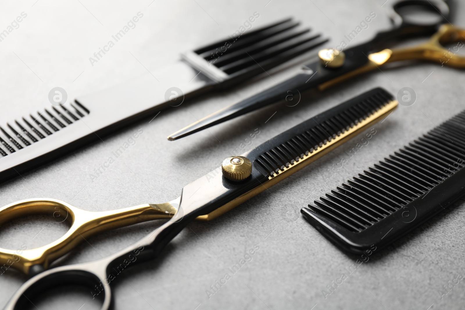 Different hairdresser's tools on grey table, closeup Photo of Different hairdresser's tools on grey table, closeup