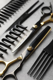 Photo of Different hairdresser's tools on grey table, closeup