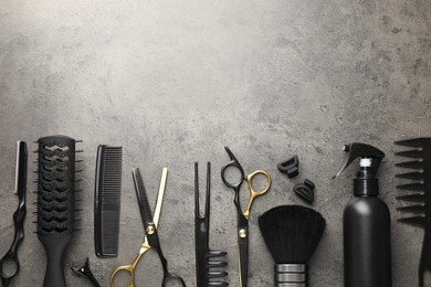 Photo of Different hairdresser's tools on grey table, flat lay. Space for text