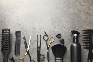 Photo of Different hairdresser's tools on grey table, flat lay. Space for text