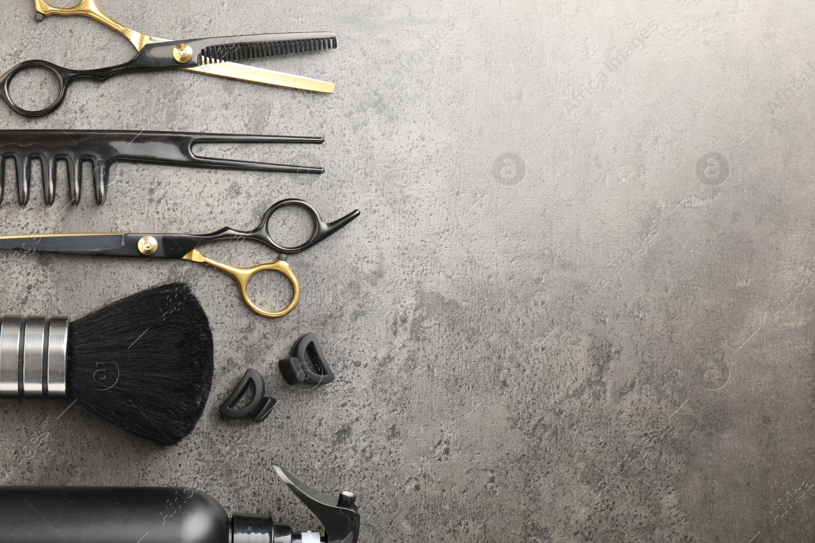 Different hairdresser's tools on grey table, flat lay. Space for text Photo of Different hairdresser's tools on grey table, flat lay. Space for text