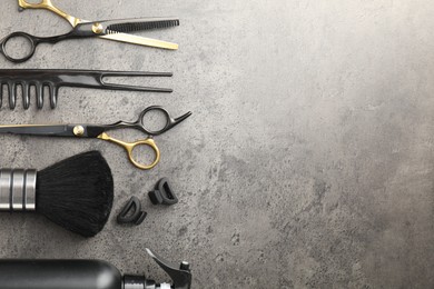 Photo of Different hairdresser's tools on grey table, flat lay. Space for text