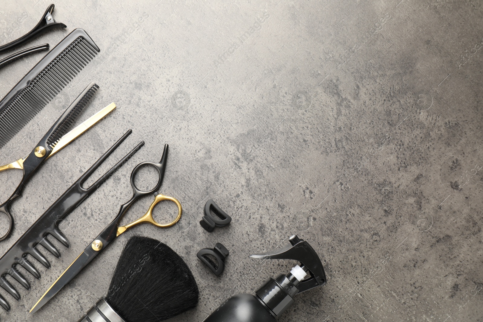 Different hairdresser's tools on grey table, flat lay. Space for text Photo of Different hairdresser's tools on grey table, flat lay. Space for text