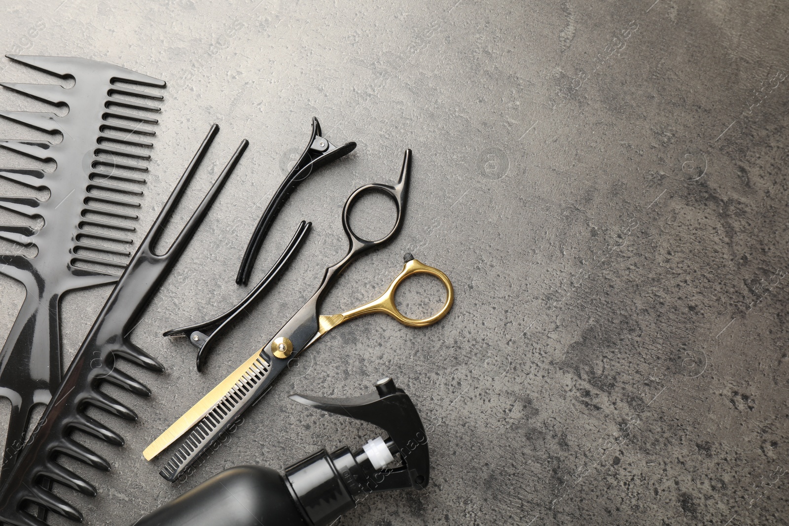 Different hairdresser's tools on grey table, flat lay. Space for text Photo of Different hairdresser's tools on grey table, flat lay. Space for text