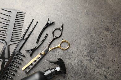 Photo of Different hairdresser's tools on grey table, flat lay. Space for text
