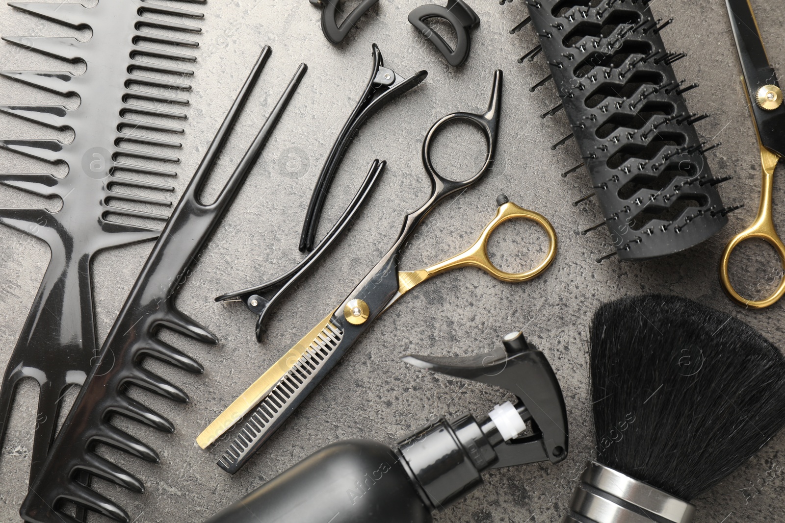 Different hairdresser's tools on grey table, flat lay Photo of Different hairdresser's tools on grey table, flat lay