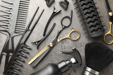 Photo of Different hairdresser's tools on grey table, flat lay