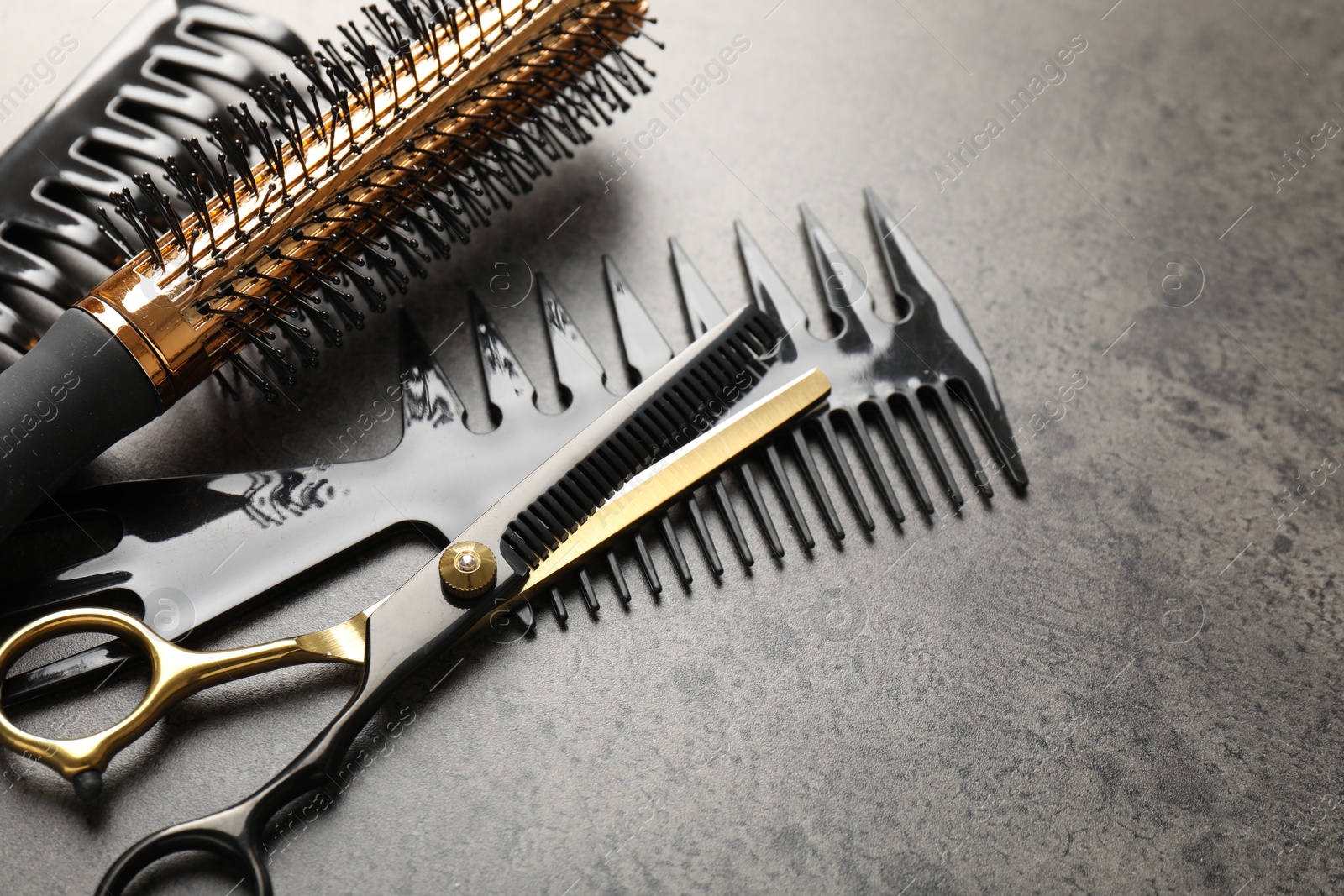 Different hairdresser's tools on grey table, closeup Photo of Different hairdresser's tools on grey table, closeup