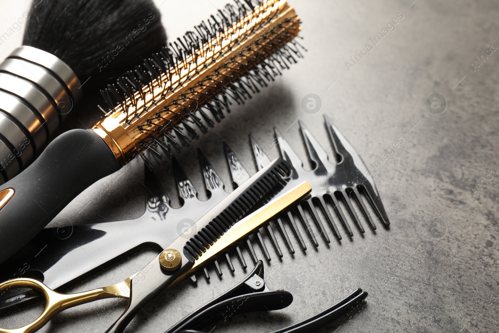 Different hairdresser's tools on grey table, closeup Photo of Different hairdresser's tools on grey table, closeup