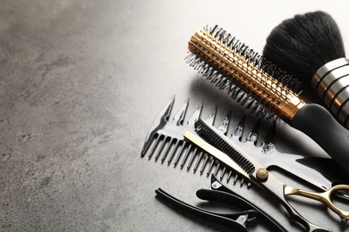 Photo of Different hairdresser's tools on grey table, closeup. Space for text