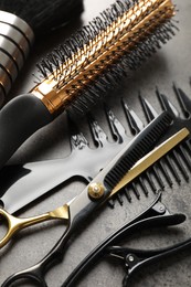 Photo of Different hairdresser's tools on grey table, closeup