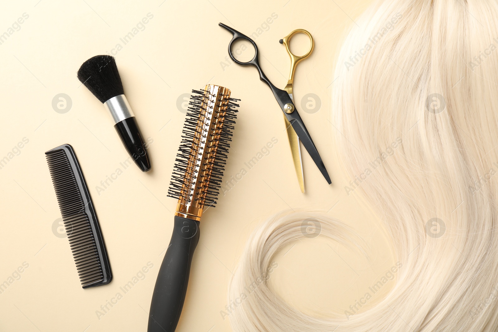 Hair lock and different hairdresser's tools on beige background, flat lay Photo of Hair lock and different hairdresser's tools on beige background, flat lay