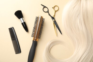 Photo of Hair lock and different hairdresser's tools on beige background, flat lay