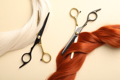 Photo of Hair locks and scissors on beige background, flat lay