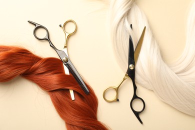 Photo of Hair locks and scissors on beige background, flat lay
