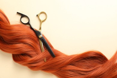 Photo of Hair lock and scissors on beige background, top view. Space for text