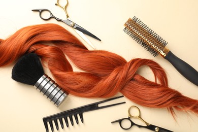 Photo of Hair locks and different hairdresser's tools on beige background, flat lay