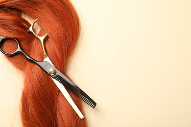 Photo of Hair locks and scissors on beige background, flat lay. Space for text