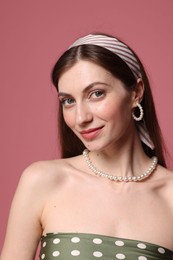 Photo of Fashionable portrait of beautiful woman in stylish outfit on pink background