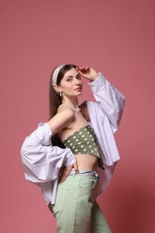 Photo of Fashionable portrait of beautiful woman in stylish outfit on pink background