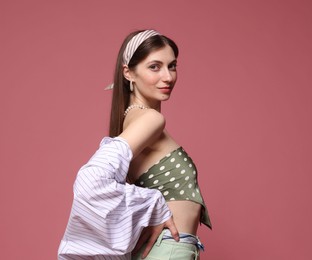 Photo of Fashionable portrait of beautiful woman in stylish outfit on pink background