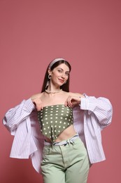 Photo of Fashionable portrait of beautiful woman in stylish outfit on pink background