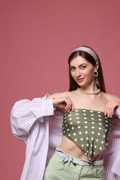 Photo of Fashionable portrait of beautiful woman in stylish outfit on pink background