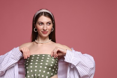 Photo of Fashionable portrait of beautiful woman in stylish outfit on pink background