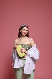 Photo of Fashionable portrait of beautiful woman in stylish outfit on pink background