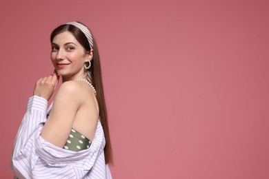 Photo of Fashionable portrait of beautiful woman in stylish outfit on pink background. Space for text