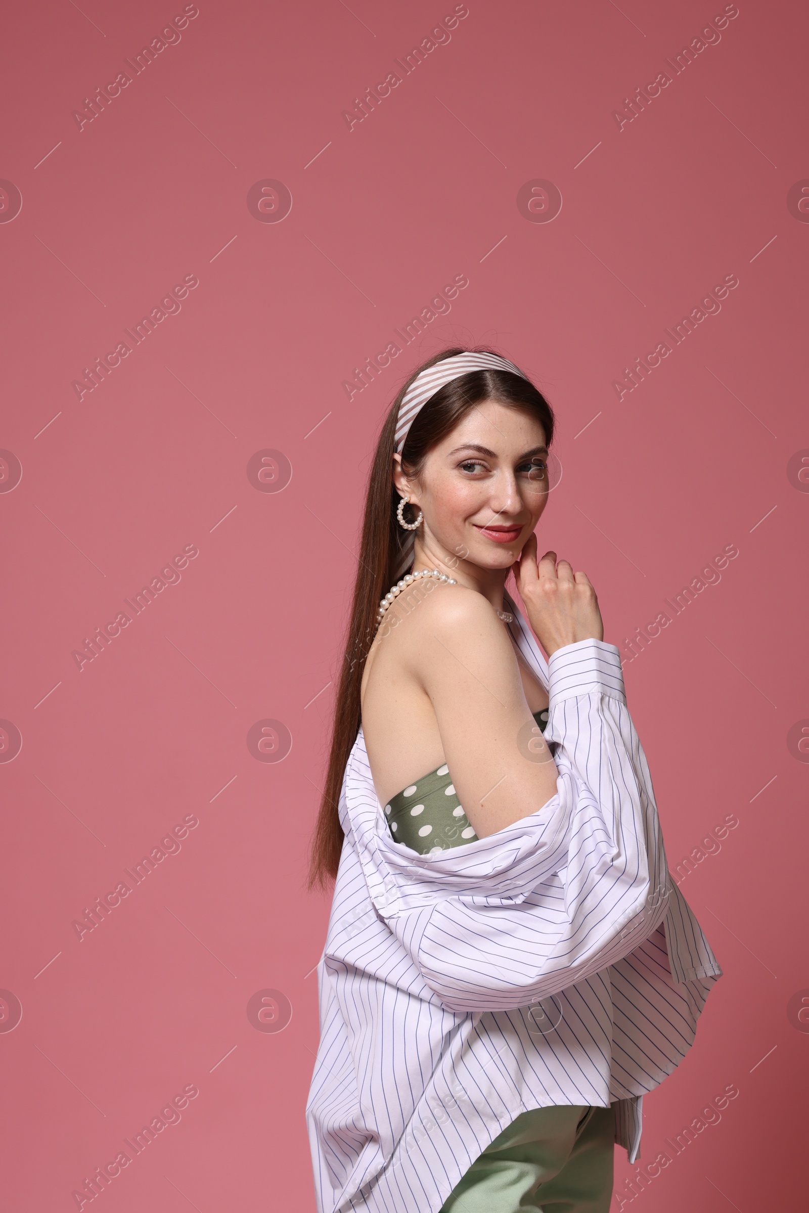 Fashionable portrait of beautiful woman in stylish outfit on pink background Photo of Fashionable portrait of beautiful woman in stylish outfit on pink background