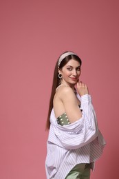 Photo of Fashionable portrait of beautiful woman in stylish outfit on pink background