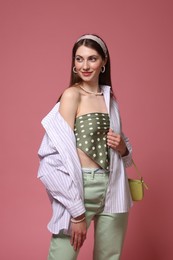 Photo of Fashionable portrait of beautiful woman in stylish outfit on pink background
