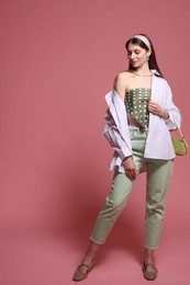 Photo of Fashionable full-length portrait of beautiful woman in stylish outfit on pink background