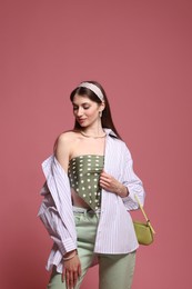 Photo of Fashionable portrait of beautiful woman in stylish outfit on pink background