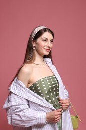 Photo of Fashionable portrait of beautiful woman in stylish outfit on pink background
