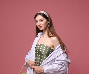 Photo of Fashionable portrait of beautiful woman in stylish outfit on pink background