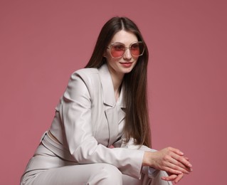 Photo of Fashionable portrait of beautiful woman in stylish outfit on pink background